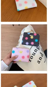 Dettaglio dei pois colorati sulla borsa in pelle testurizzata da donna con logo dorato