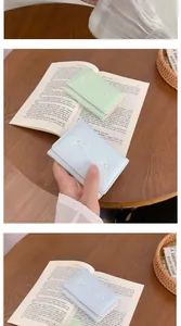Detail of light green and blue mini wallets with white bow and pearl decoration