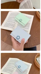 Detailed view of mini faux leather wallet with floral buckle on vintage book background