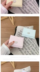 Detailed close-up of macaron color PU leather wallets with a cute metal bear logo charm