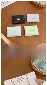 Détail d'un portefeuille compact en similicuir avec fentes pour cartes et compartiments