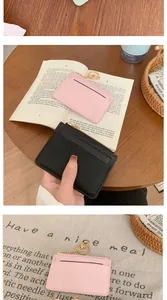 Detail showing multi-slot card holder with zipper closure and golden keychain in pink and black