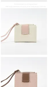 Details der Blumenprägung und Metallbeschläge an einer kurzen Reißverschluss-Brieftasche