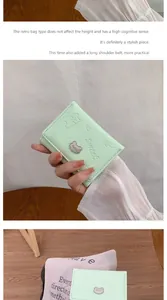 Detail of mint green tri-fold PU leather wallet with cartoon embossing and bear charm