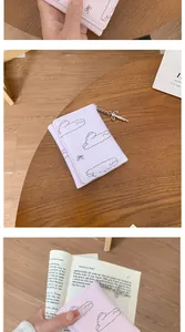 Détail du portefeuille lavande à trois volets avec nuages et pendentif nœud en métal