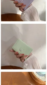 Détail de mini portefeuilles lavande et menthe avec nœuds blancs et lettrage SWEET gravé