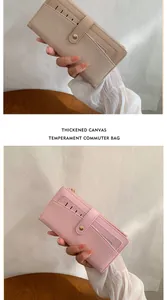 Détail de portefeuilles longs beige et rose en toile épaisse avec fermeture éclair et bouton