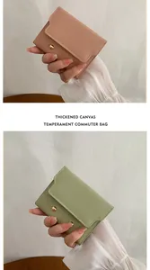 Detail of pink and green canvas wallets with gold snap button and textured finish