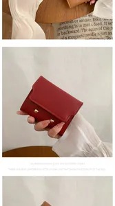Close-up of red and brown folded wallets with gold snap buttons and leather texture
