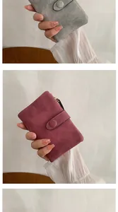Close-up of compact faux suede wallet in grey and red with buckle and zipper detail