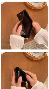 Vista dettagliata di un portafoglio in pelle nera con slot per carte e zip dorata