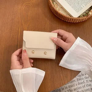 Short cream bi-fold wallet for women with lychee texture and metallic stud accents