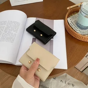 Minimalist leather women wallet with gold stud accents in black and beige colors