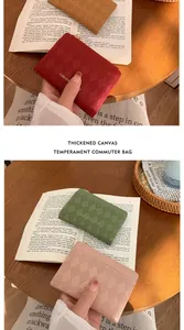 Dettaglio di portamonete trapuntati in rosso, marrone, verde e rosa con chiusura lampo