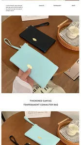 Detail of thickened canvas commute clutch bags with golden logo and wristlet strap