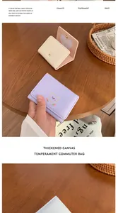 Detail einer kompakten dreifach gefalteten Brieftasche mit Bärenstickerei und Herz-Kartenfach