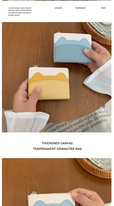 Detail of mini cat-ear wallets in blue and yellow PU leather with thickened canvas