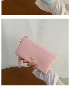 Detail view of pink PU leather long wallet with golden buckle and wrist strap