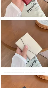Gros plan des coutures fines et du logo sur un petit portefeuille en cuir souple
