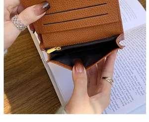 Detail showing internal card slots and golden zipper pocket of brown lychee leather wallet