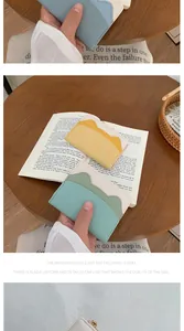 Detail of scalloped edge card holders in pastel blue, yellow, and mint green with stitching