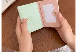 Dettaglio del mini portafoglio bicolore menta e rosa con motivo orsetto in rilievo