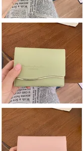 Primo piano di portafogli rosa e verde pastello con incisione e bordo dorato a onda