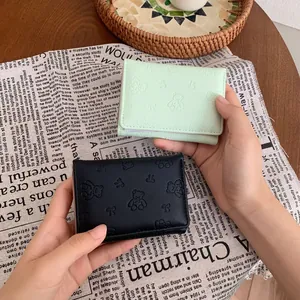 Portafoglio corto minimalista a tre ante con rilievo di orso in verde e pelle nera