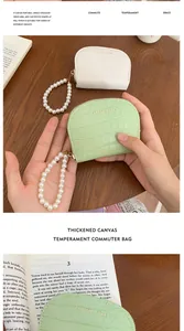 Detail of crocodile pattern card holder with pearl strap in light green and white