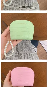 Detail of crocodile pattern coin purse with pearl wristlet strap in mint and pink colors