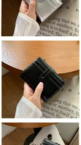 Dettaglio porta carte minimalista in pelle con scomparti e chiusura a zip dorata