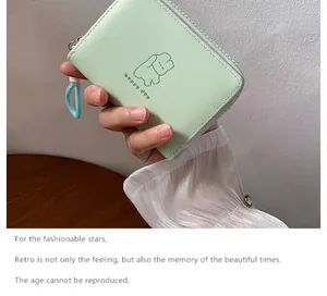 Detail of mint green faux leather wallet featuring an embossed happy day animal motif