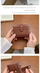 Dettaglio del portafoglio in pelle marrone vintage con cuciture e tracolla