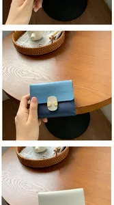 Detail of color-block leather mini wallet with metal buckle clasp on wooden background