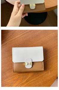 Close-up of a compact two-tone faux leather wallet with gold metal buckle detail