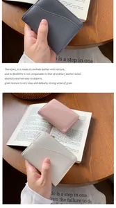 Dettaglio della trama in pelle bovina venata su portafogli nei colori grigio e rosa