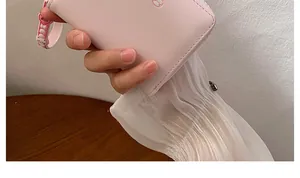 Dettaglio di un portafoglio corto rosa con cerniera, decorazione cartoon e cinturino