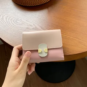 Short women's bifold wallet in beige and pink faux leather with a green strap buckle
