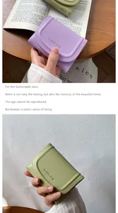 Détail du logo et des coutures de précision sur les portefeuilles en cuir vert et violet