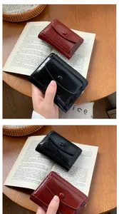 Close-up of compact faux leather wallets with glossy oil wax texture and snap closure