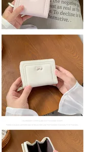 Dettaglio del portafoglio corto crema con fiocco e scomparti per carte a fisarmonica
