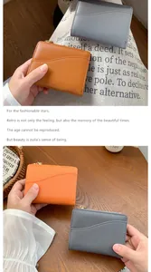 Dettaglio di portafogli corti in pelle con zip dorate e fessure per carte in marrone e grigio