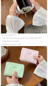 Dettaglio di portafogli in pelle PU rosa e verde con fiocco e scomparti per carte