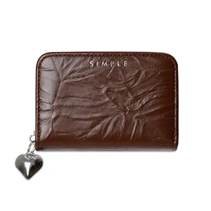 Close-up of brown crinkle texture leather card holder with heart zipper pull and engraving