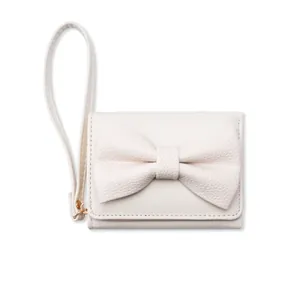 Dettaglio dell'elegante portafoglio in pelle beige con fiocco grande e cinturino