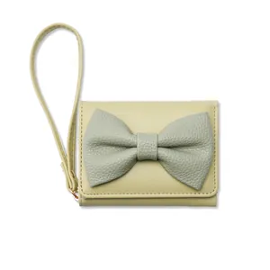Dettaglio del mini portafoglio verde chiaro con cinturino e grande fiocco decorativo