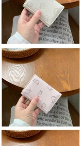 Dettaglio del mini portafoglio rosa con disegni di conigli e scritta dorata elegante