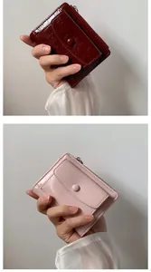 Detail of burgundy and pink crinkled leather wallets with zip and snap button closure