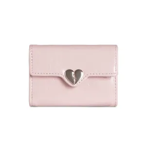 Dettaglio macro del portafoglio in pelle rosa con fibbia a cuore in metallo