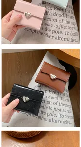 Three-fold women wallet with silver heart clasp showing pink, brown and black leather texture